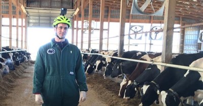 Adrian Barragan in a barn with cows